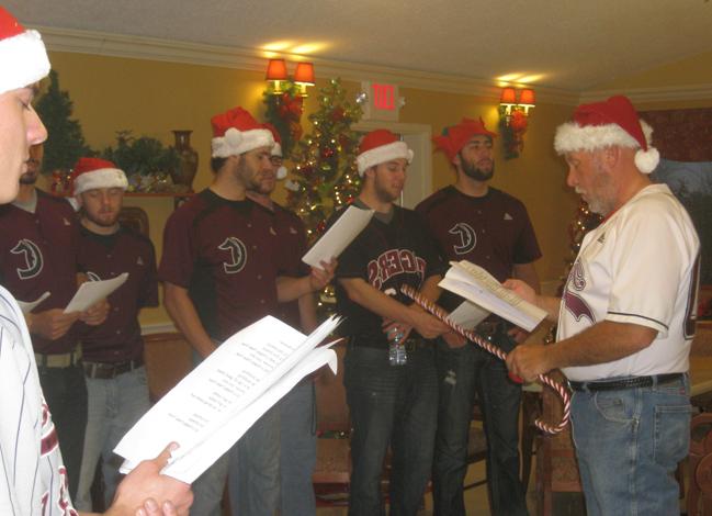 Beauford Sanders, left, head coach of the Campbellsville University baseball team, gets his players in the Christmas spirit as they sing Christmas carols to residents of the Grand View Nursing & Rehabilitation Facility. The Tiger baseball team took a break from studying for finals and spent the afternoon Dec. 8 singing Christmas carols and visiting with residents. (Photo courtesy of Barbara Sanders)